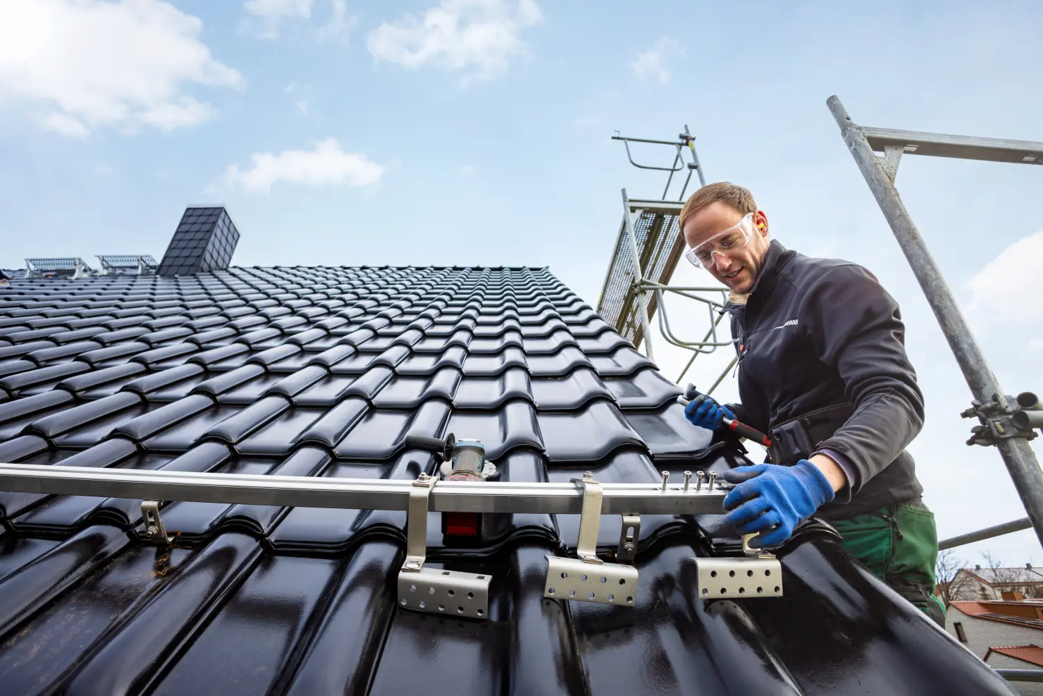 Handwerker installiert das Solarpanel-Montagesystem auf einem Dach
